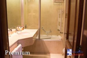 a bathroom with a shower and a sink and a tub at Palmar Hotel Casino in Concordia