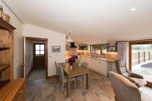 a kitchen with a table and a dining room at The Old Cowstall in Somerton