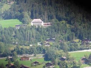 um grande edifício no topo de uma colina com casas em Apartment Fluehüsli by Interhome em Gstaad