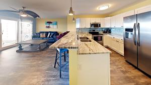 uma cozinha com electrodomésticos de aço inoxidável e uma sala de estar em Put-In-Bay Waterfront Condo #108 em Put-in-Bay