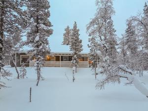 a house in the snow with snow covered trees at Holiday Home Hilla b by Interhome in Saariselka