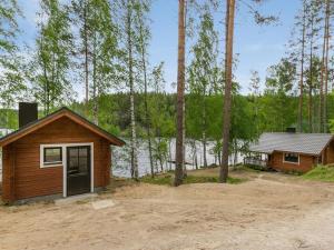 a cabin in the woods next to a lake at Holiday Home Vuorilahti by Interhome in Savonranta