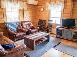 ein Wohnzimmer mit Ledermöbeln und einem Flachbild-TV in der Unterkunft Holiday Home Värikatti by Interhome in Vuokatti