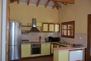 een keuken met een roestvrijstalen koelkast en kasten bij VILLA ISMINI, Skiathos in Skiathos-stad