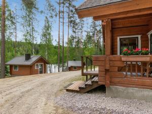 a log cabin with a porch and flowers on it at Holiday Home Vuorilahti by Interhome in Savonranta