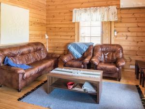 ein Wohnzimmer mit 2 Ledersofas und einem Tisch in der Unterkunft Holiday Home Värikatti by Interhome in Vuokatti