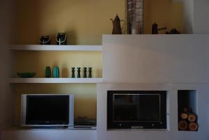 een woonkamer met een flatscreen-tv en planken bij VILLA ISMINI, Skiathos in Skiathos-stad +16 foto's