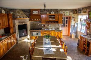 a kitchen with a table and chairs and a fireplace at Casa da Tanquinha in Beiral do Lima