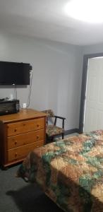 1 dormitorio con 1 cama, vestidor y TV en Collingwood MOTEL en Collingwood