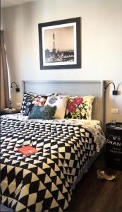 um quarto com uma cama preta e branca com almofadas em EDIFICIO LORENA em São Paulo