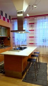 a kitchen with a stove and two stools at Fuksija House in Daugavpils +27 photos