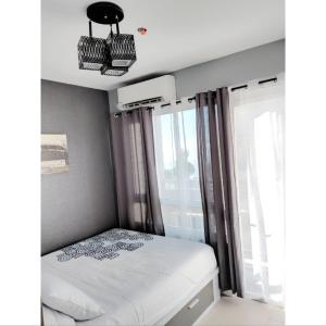 - une petite chambre avec un lit et une fenêtre dans l'établissement The Penn Room Tagaytay at Cool Suites, à Tagaytay