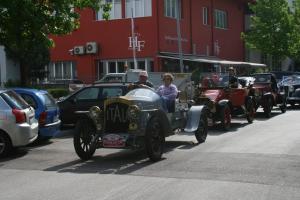 an old car driving down a street with other cars at Hotel Fiera in Bolzano