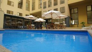 a pool with umbrellas in the middle of it at Hotel Diego de Almagro Santiago Centro in Santiago