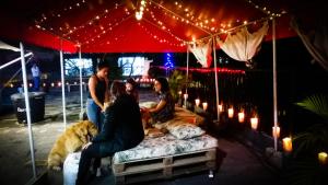 un grupo de personas sentadas en una cama bajo una tienda en Selvática Alojamiento Eco en Medellín