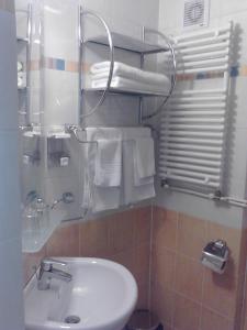 La salle de bains est pourvue d'un lavabo et de toilettes avec des serviettes. dans l'établissement Hotel Iasicon, à Lacu Roșu