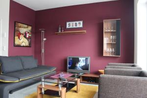 salon z kanapą i telewizorem w obiekcie Ferienwohnung Augustin w mieście Orscholz