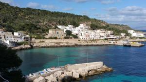 a group of white buildings on a hill next to the water at Casa Levanzo in Levanzo