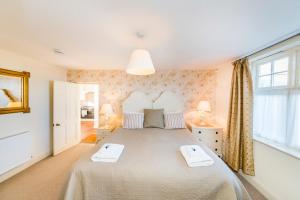 a bedroom with a large bed with two towels on it at Sands Apartment in Whitby