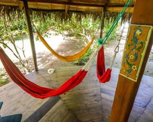 ein paar Hängematten hängen vom Dach in der Unterkunft Las Cabañas de la Iguana in Ayampe