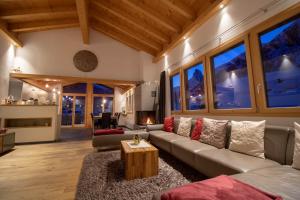 ein Wohnzimmer mit einem Sofa und einem Tisch in der Unterkunft Chalet A la Casa in Zermatt