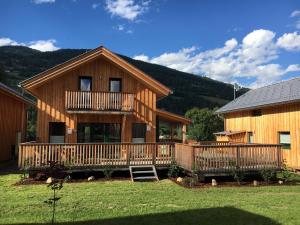 a log cabin with a deck and a house at Hirsch Chalet in Sankt Lorenzen ob Murau