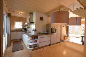 a kitchen with white cabinets and a large window at Hirsch Chalet in Sankt Lorenzen ob Murau