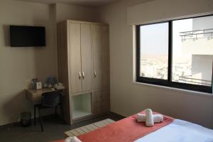 a bedroom with a bed and a desk and a window at innova8ion in Bethlehem