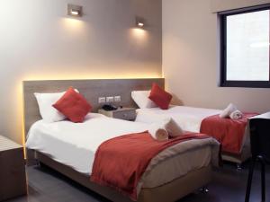Habitación de hotel con 2 camas con almohadas rojas en innova8ion, en Bethlehem
