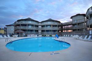 a swimming pool in front of a building at Outer Banks Beach Club in Kill Devil Hills