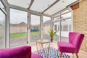 a living room with purple chairs and windows at The Buddha House Huntingdon Boutique Rooms in Godmanchester