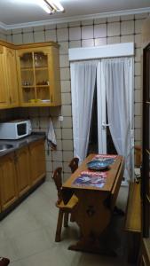 eine Küche mit einem Holztisch und einer Mikrowelle in der Unterkunft Casa Nicolás in Avila