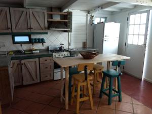 a kitchen with a wooden table and chairs and a refrigerator at El Tamarisco in Puerto Pirámides