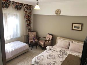 BurhaniyeにあるPekcan Otelのベッドルーム1室(ベッド1台、椅子付)