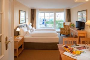 a hotel room with a bed and a table with a tray of fruit at Dorint Strandresort & Spa Westerland/Sylt in Westerland