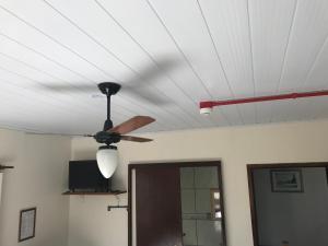 un ventilador de techo con una luz en el techo en Pousada da Bila, en Guarda do Embaú