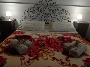 a bed with a floral bedspread and two pillows on it at Villa Curti in Rome