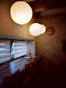 three lights are hanging above a bar with chairs at Statek "Two brooms", Apartment in Mirkovice