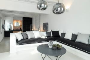 a living room with a black and white couch and a table at Nimbus Mykonos in Agios Stefanos