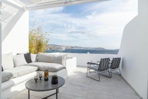 a living room with a couch and a table at Nimbus Mykonos in Agios Stefanos