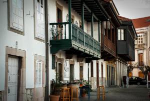 a building with a balcony and tables on a street at Atico Chic con Encanto in Muros de Nalón