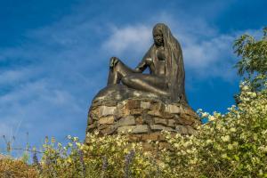 una estatua de una mujer sentada en una roca en ** Ferienwohnung im Weltkulturerbe nahe Loreley en Niederburg