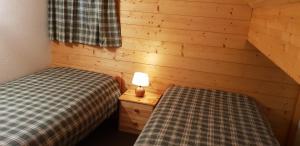 a bedroom with two beds and a lamp on a night stand at Chalet cosy & confort Spa,Sauna,Pétanque,VE - Top situation à Gérardmer in Gérardmer +24 photos
