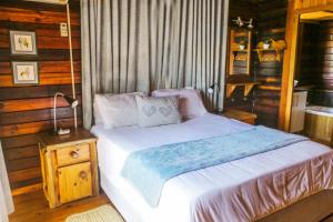 Sodwana Bay Lodge House 34 في سودوانا باي: غرفة نوم بسرير وجدار خشبي