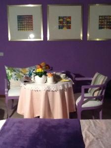 a table in a room with a purple wall at B&B Cosi fan Tutte in Desenzano del Garda