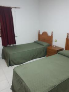 a bedroom with two beds and a dresser at La redonda in San Roque