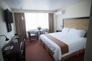 a hotel room with a large bed and a table at Best Western Plus Hotel Terraza in San Salvador