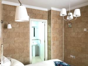 - une chambre dotée d'un mur en pierre avec un lit et deux lumières dans l'établissement Apartamento !!VIVE JEREZ!!, à Jerez de la Frontera 38 autres photos
