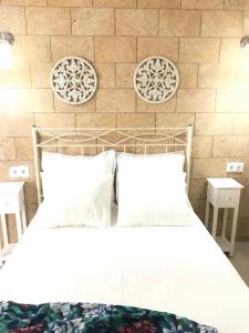 une chambre avec un lit blanc et un mur de briques dans l'établissement Apartamento !!VIVE JEREZ!!, à Jerez de la Frontera