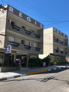 a building with a sign for a hotel at Regis Hotel I in Registro